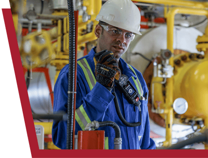 Un operaio del settore petrolifero e del gas utilizza il microfono RSM di Blackline Safety per comunicare con la propria squadra.